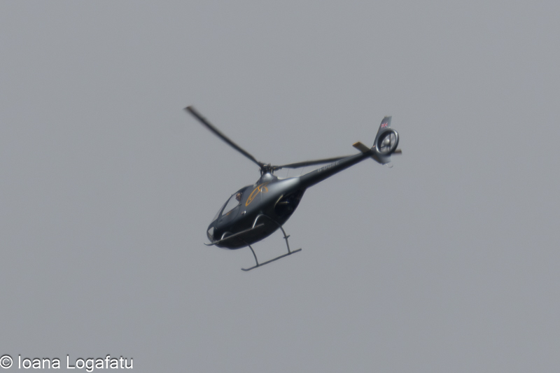 Helicopter soaring across a cloudy sky at dawn